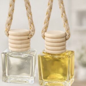 Two car oil diffusers filled with liquid. The diffusers are clear and have a light wood cap and a tan string.