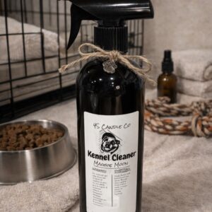 A 16 oz black spray bottle with a tan string attached to the tied in a bow with a sliver pet paw cahrm. A white lable with product information: 4S Candle Co, Kennel Cleaner, Maggie Moon, Directions, and Warning label. A picute of an english bulldog is centered on the label. THe backgorund consist sof a partial view of a kennel, another small spray bottle, a rope, a stack of tan towls, and a dog food bowl with dog food.