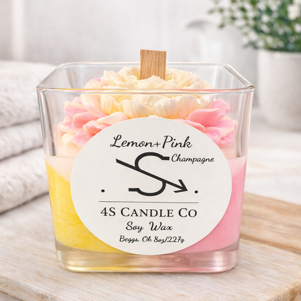 candle in a square clear vessel, tricolor candle with pink, red, and yellow wax in a triagnle stacked design, wood wick, flower embeds. Front has the 4S Candle Co logo labeled with the name Lemon + Pink Champagne. Label has soy wax, Begs, Ok and 8oz/227g printed.